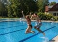 Zwei Badegaeste springen ins Schwimmerbecken des Freibads Ortrand
