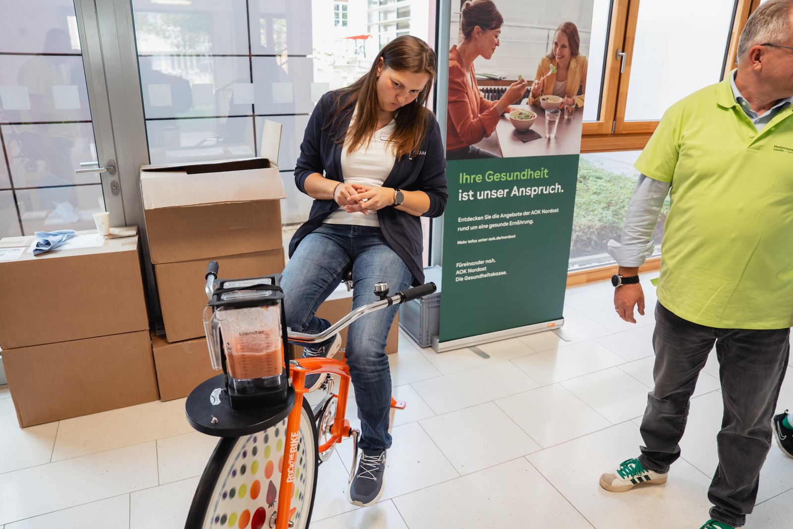 Eine Besucherin tritt auf einem Ergometer in die Pedale