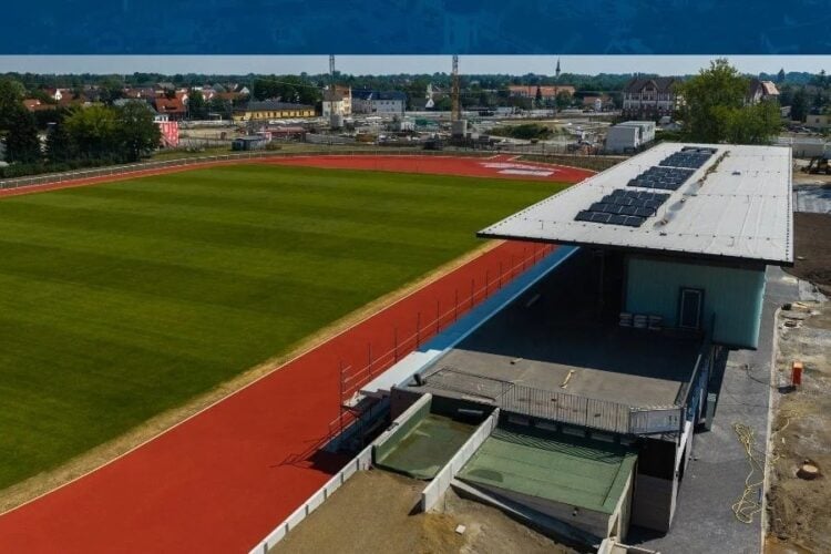 Luftbild des Spreewald Stadions Luebbenau mit Rasenplatz, Laufbahn und neuem Sozialgebaeude