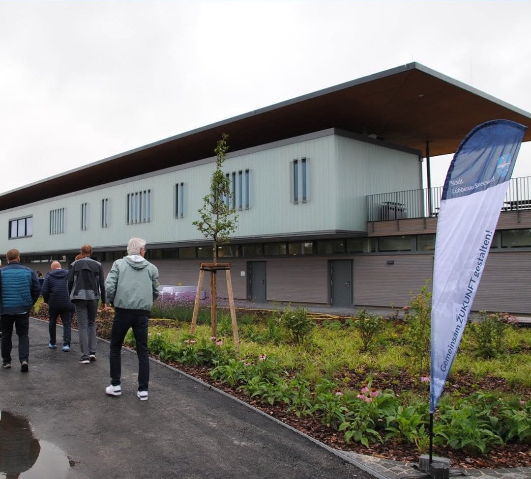 Besucher gehen auf das neue Sozialgebäude am Spreewald Stadion zu
