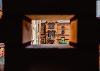Blick durch eine Maueröffnung auf die Backsteinfassade des Forster Museums für Textil- und Industriegeschichte