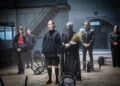 Linn Reusse als Hamlet im Hoodie inmitten des Ensembles im Hangar 1 in Cottbus