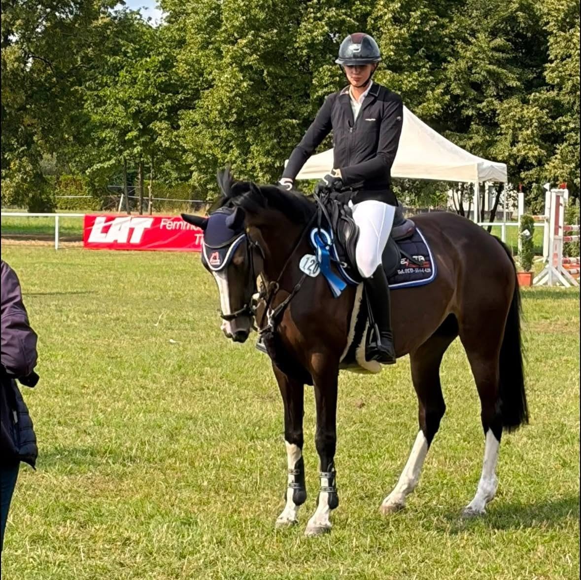 Reiterin mit blauer Schleife und Siegerdecke