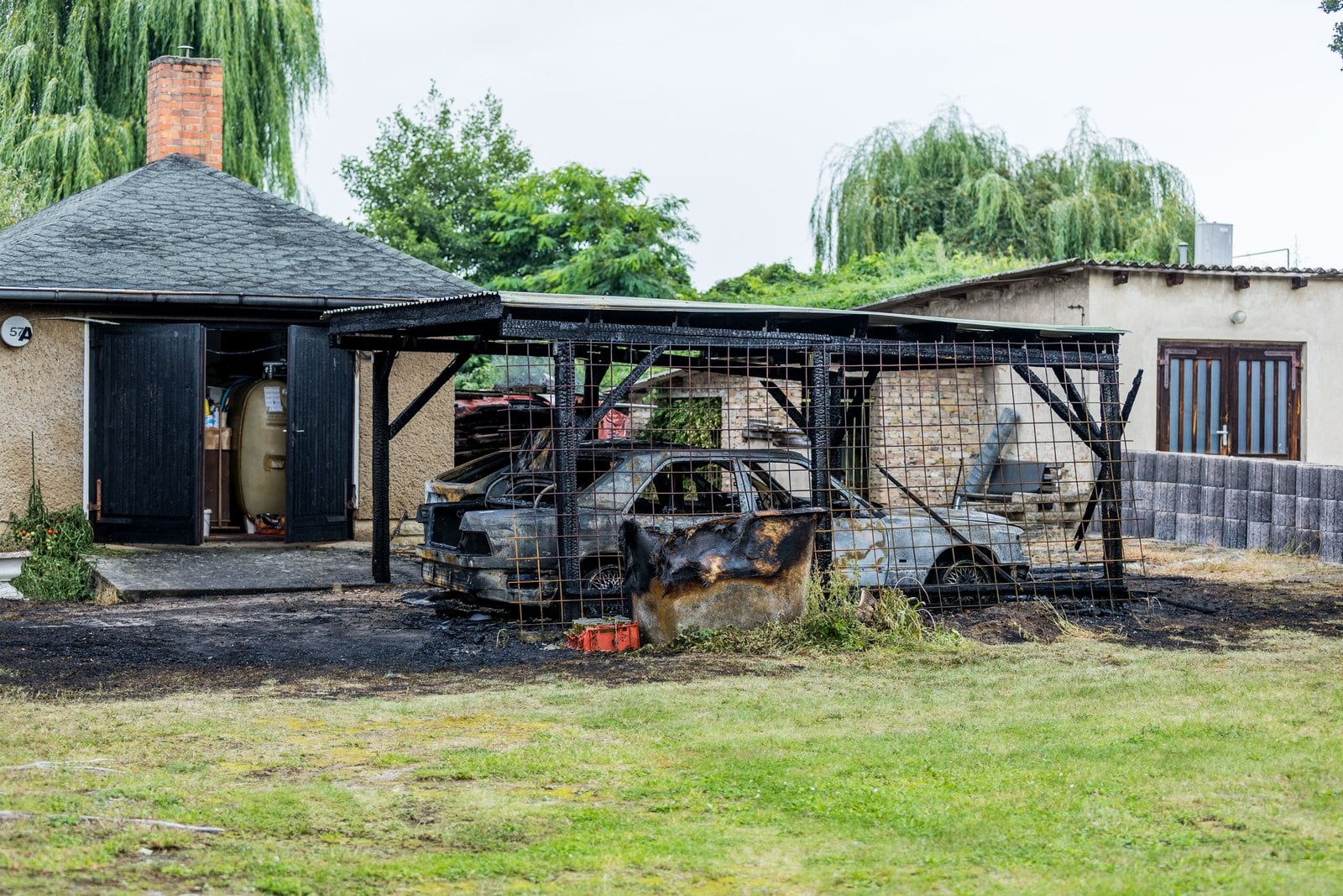 Feuerwehrleute löschen den brennenden Carport in Groß Köris