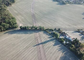 Luftbild: Die auf dem Feld markierte Trassenführung der geplanten Ortsumfahrung verläuft nahe an der Wohnbebauung