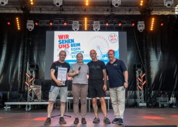 Vier Personen mit Spendenbox auf der Hauptbühne des EisenhüttenStadtfests