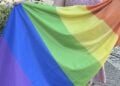 Ausgebreitete Regenbogenflagge in den Farben Violett, Blau, Grün, Gelb, Orange und Rot