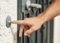 Hand klingelt an einer Haustür – Symbolbild zum Haustürbetrug