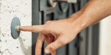 Hand klingelt an einer Haustür – Symbolbild zum Haustürbetrug