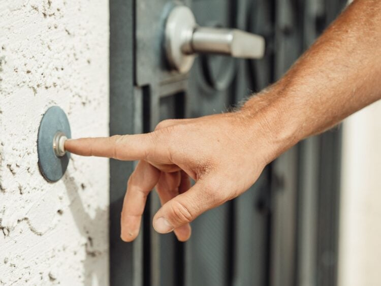 Hand klingelt an einer Haustür – Symbolbild zum Haustürbetrug