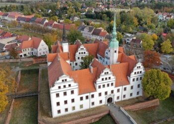 Schloss Doberlug aus der Luft, umgeben von Wallanlagen und Baeumen