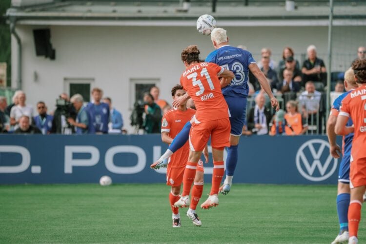 Kopfballduell zwischen einem Krieschower und einem Mainzer Spieler im DFB-Pokal