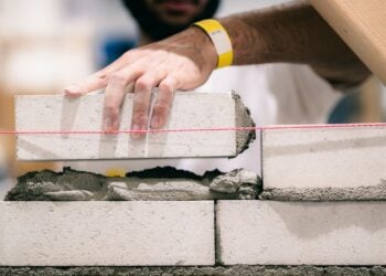 Auszubildender im Maurerhandwerk bei der Arbeit auf einer Baustelle