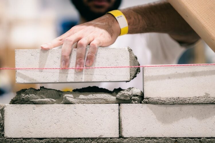 Auszubildender im Maurerhandwerk bei der Arbeit auf einer Baustelle