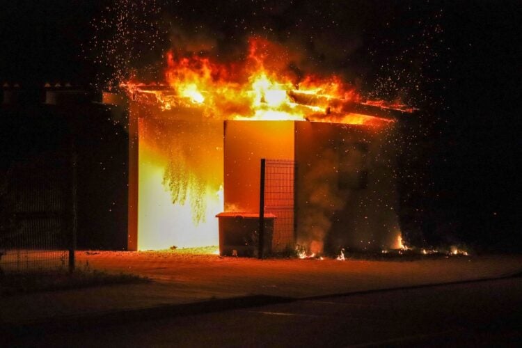 Ein Carport steht in der Nacht in Vollbrand, Funken fliegen