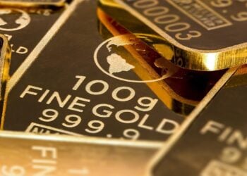 Gestapelte Goldbarren vor dunklem Hintergrund