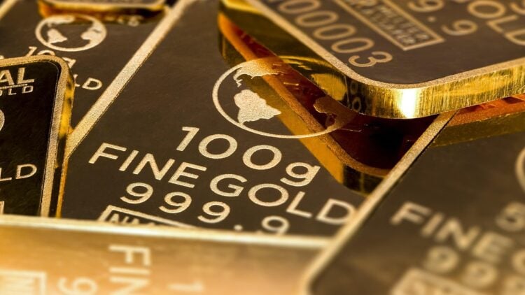 Gestapelte Goldbarren vor dunklem Hintergrund