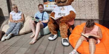 Kinder lesen auf Sitzsäcken im Katzengehege des Forster Tierheims vor