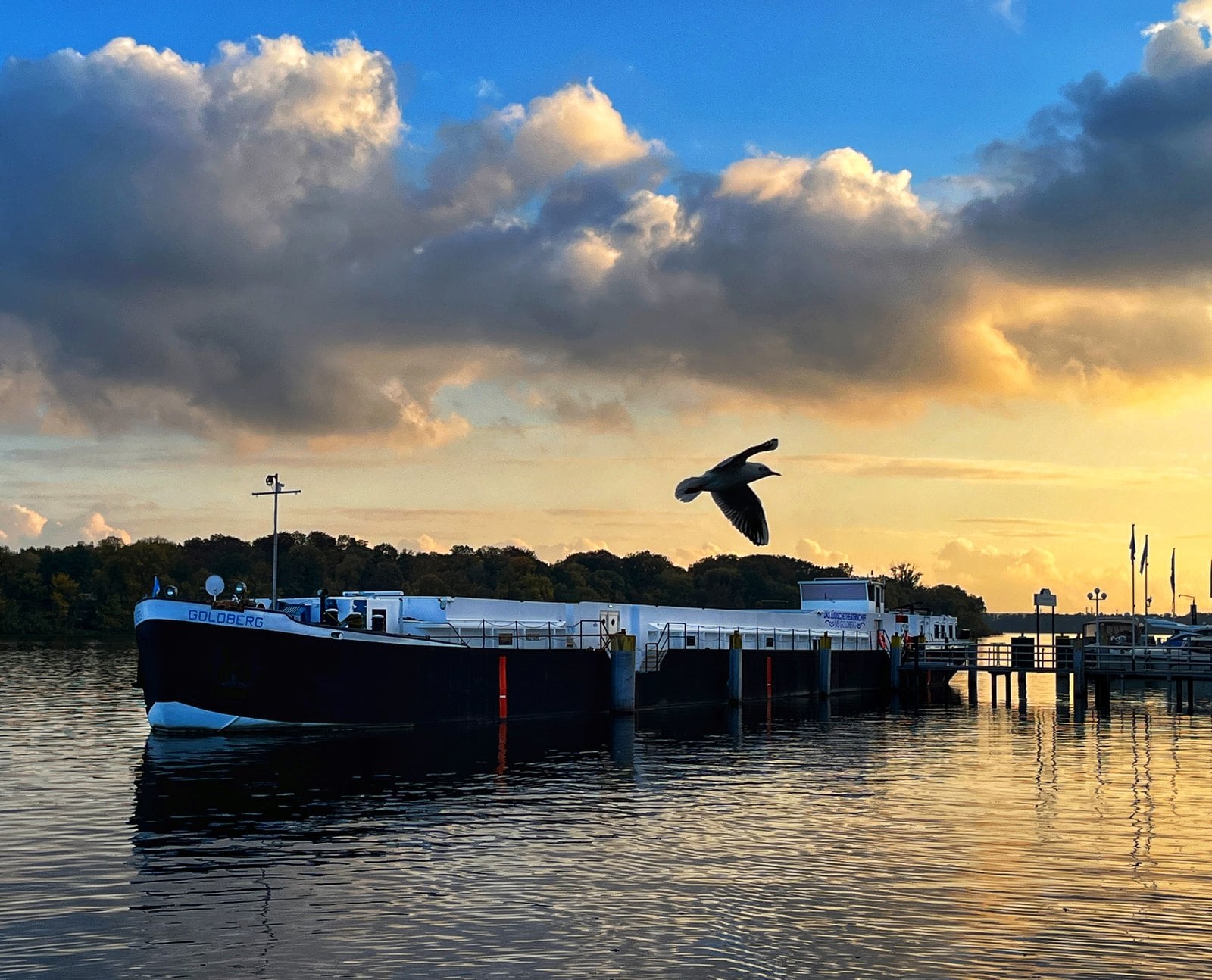 Das Kulturschiff MS Goldberg bei Sonnenuntergang am Anleger