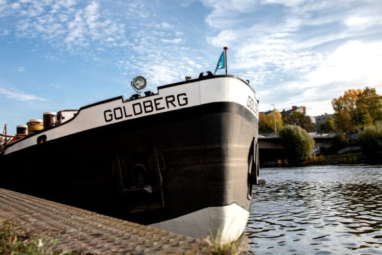 Bug des Kulturschiffs MS Goldberg mit Schriftzug am Ufer