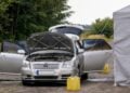 Ausgebranntes Auto mit geöffneter Motorhaube in Cottbus