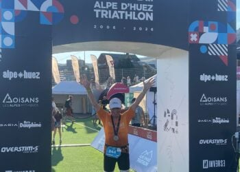 Reinhard Drogla hebt im Zielbogen des Alpe d'Huez-Triathlons die Arme