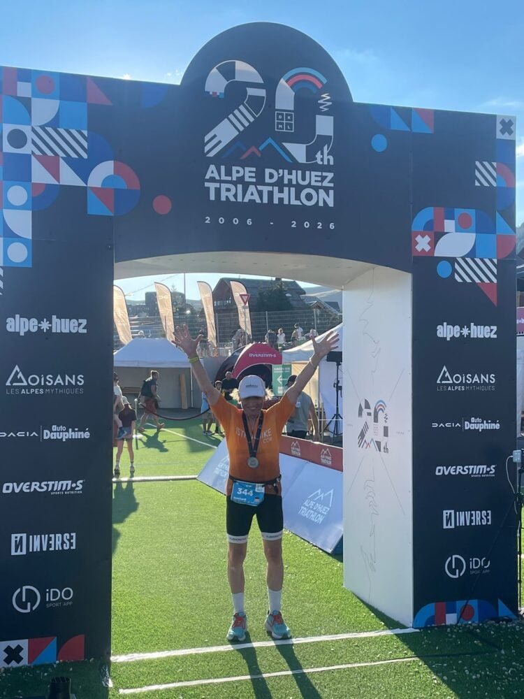 Reinhard Drogla hebt im Zielbogen des Alpe d'Huez-Triathlons die Arme