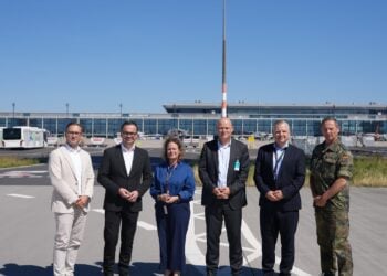 Sechs Teilnehmer des Sicherheitsgesprächs stehen auf dem Vorfeld vor dem BER-Terminal
