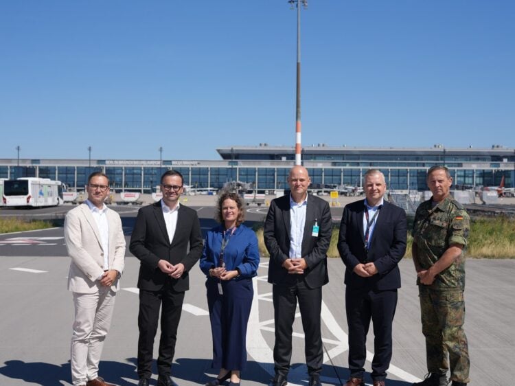Sechs Teilnehmer des Sicherheitsgesprächs stehen auf dem Vorfeld vor dem BER-Terminal