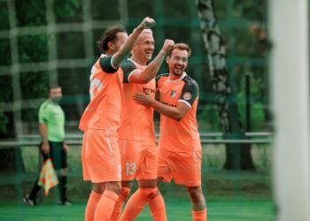 Drei Fußballer umarmen sich jubelnd vor dem Tor