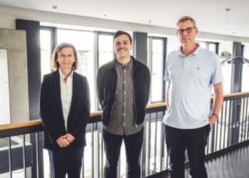Drei Personen stehen nebeneinander auf einer Galerie im BTU-Gebäude