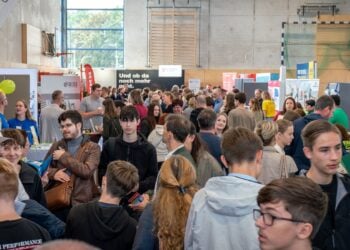 Jugendliche zwischen den Ständen der Ausbildungsmesse in der Turnhalle des Oberstufenzentrums