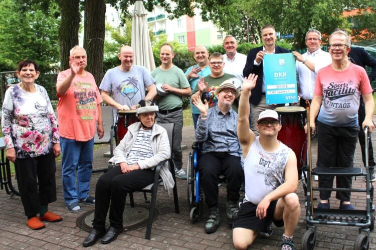 Gruppenbild mit Spendenscheck vor der DRK-Wohnstätte in Senftenberg