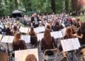 Blasorchester mit Dirigent bei einem Konzert vor Publikum im Freien