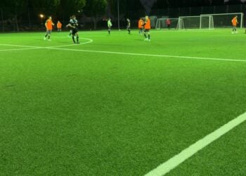 Fußballplatz unter Flutlicht am Abend