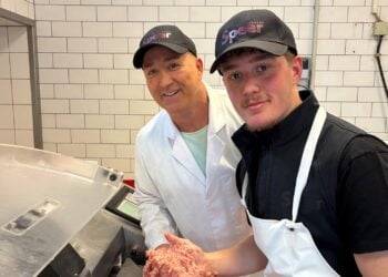 Eddie Speer und sein Vater Lars stehen an der Maschine in der Fleischerei Speer in Cottbus