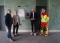 Drei Männer nehmen einen Defibrillator am Spreewald Stadion in Betrieb