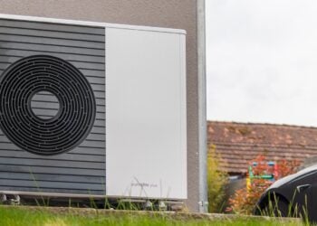Außeneinheit einer Luft-Wasser-Wärmepumpe an der Wand eines Wohnhauses
