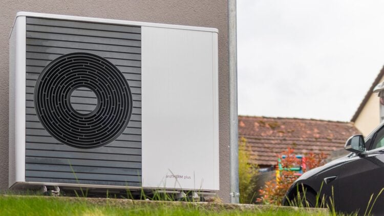 Außeneinheit einer Luft-Wasser-Wärmepumpe an der Wand eines Wohnhauses