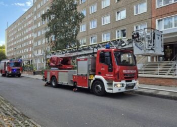 Feuerwehrfahrzeuge mit Drehleiter vor einem Plattenbau in Cottbus-Sandow