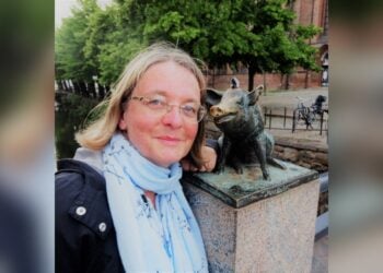 Porträt der Schriftstellerin Grit Poppe neben einer Bronzefigur