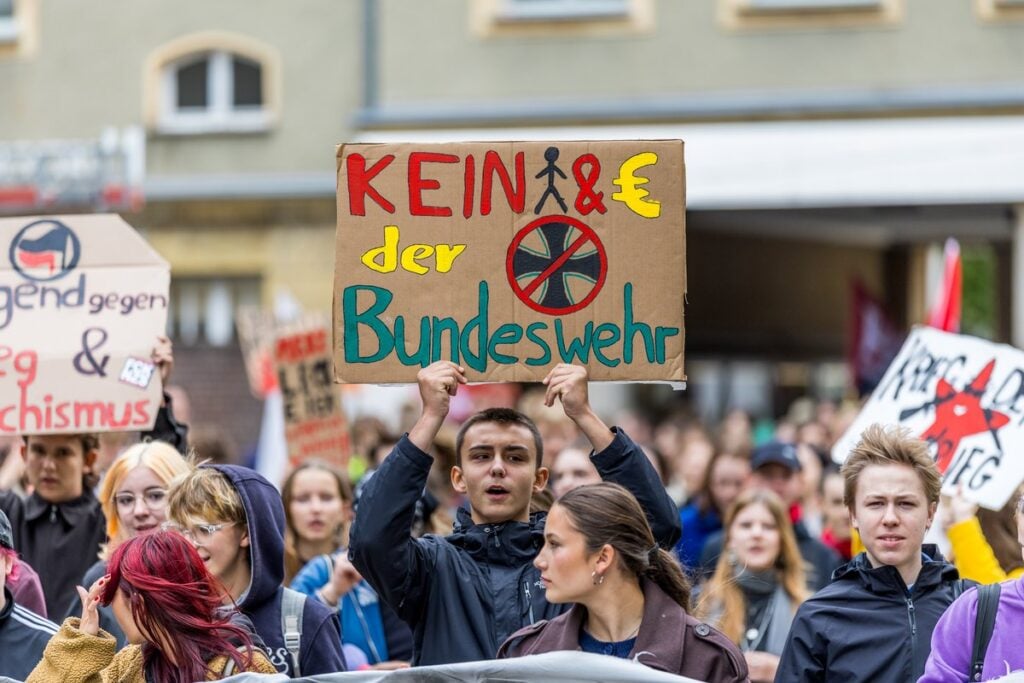 Ein Schüler hält beim Schulstreik in Cottbus ein Schild gegen die Bundeswehr hoch