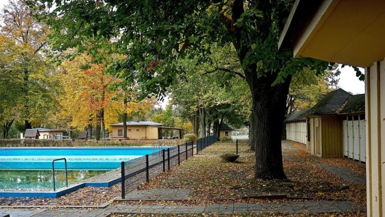 Schwimmbecken und Holzbauten des Sommerbads Vetschau unter Bäumen