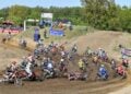 Motocross-Fahrer beschleunigen nach dem Start durch die erste Kurve