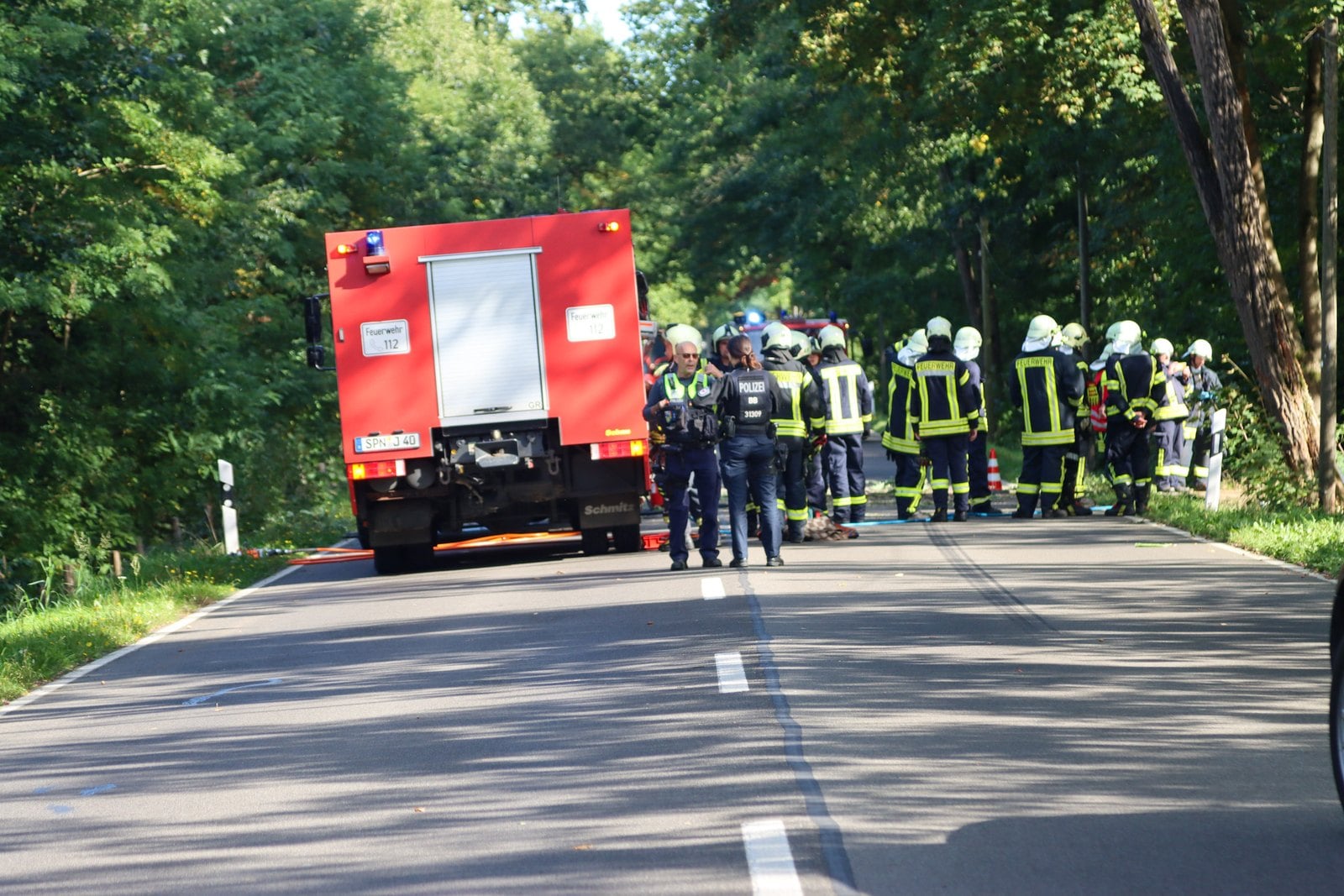 Feuerwehrleute und Polizei an der Unfallstelle auf der B156