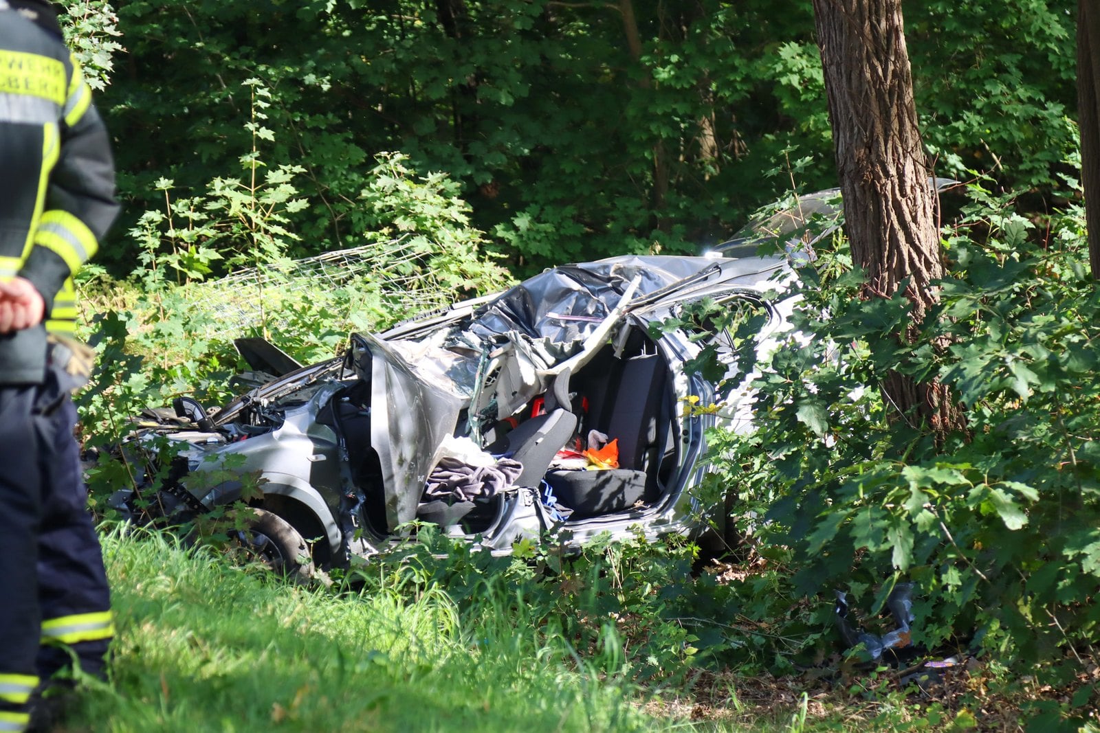 Stark beschädigtes Auto neben der B156 zwischen Bäumen