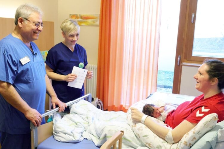 Chefarzt Maher El-Kaissi und Familienhebamme Beatrice Handschack am Bett einer jungen Mutter mit Baby