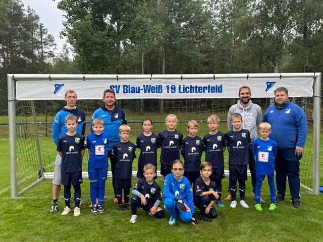 Die Waldkicker des SV Blau-Weiß 19 Lichterfeld mit ihren Trainern vor dem Tor
