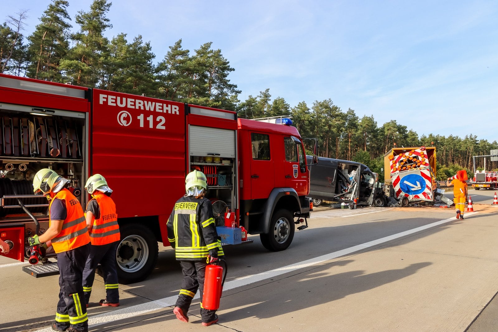 Feuerwehrleute und Löschfahrzeug an der Unfallstelle auf der A13