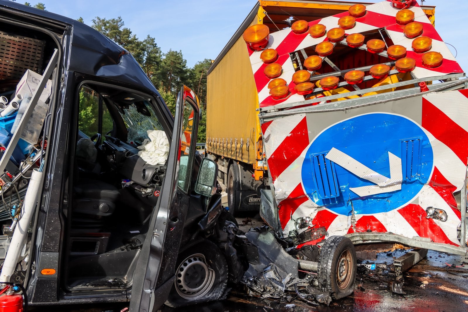 Die zerstörte Fahrerseite des Transporters neben dem Schilderwagen